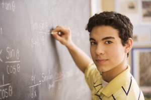 Young man writing on a chalk board